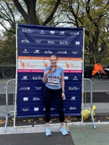 Young female runner posing with marathon medal