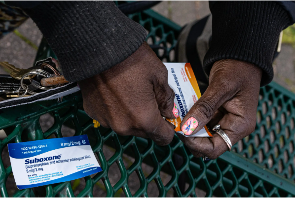 Pair of hands holding a package of Suboxone