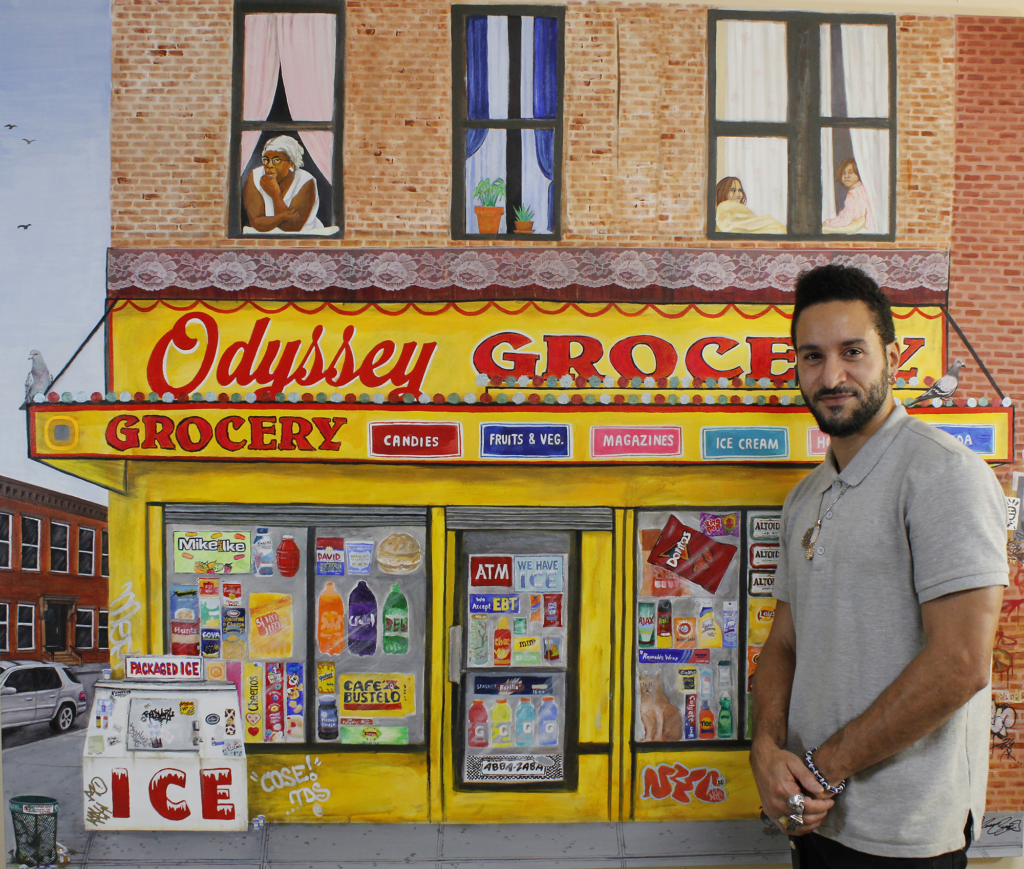 Adult male artist standing next to his painting of a NYC bodega