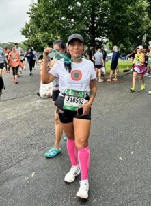 Female runner with medal after Queens 10K
